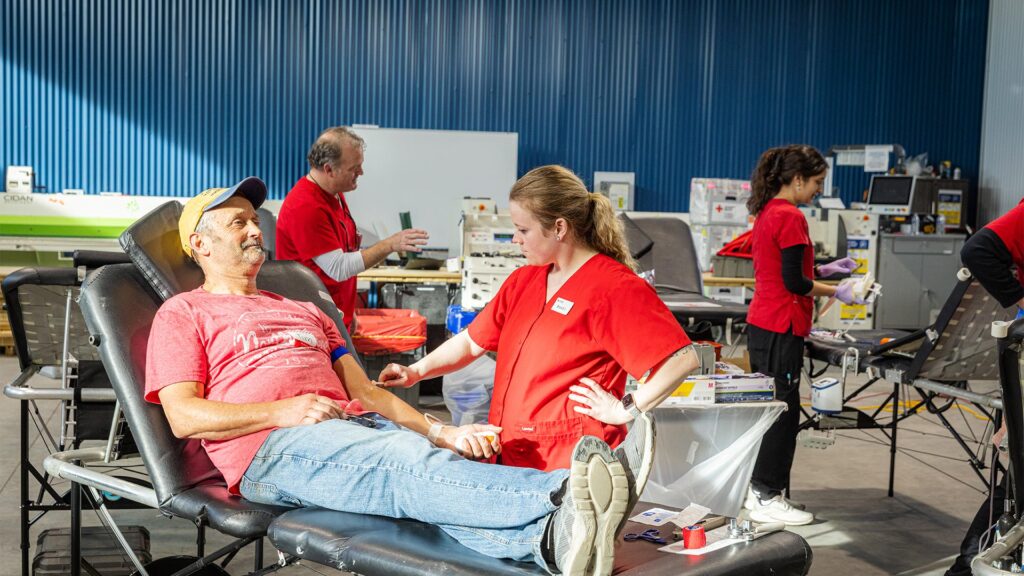 Blood donor receiving care from Red Cross staff during community blood drive