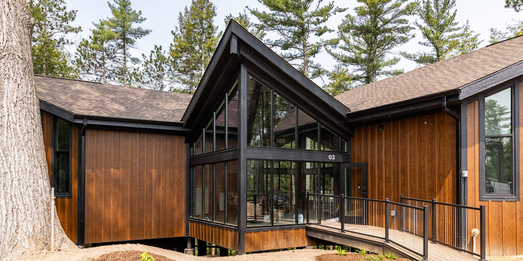Modern custom home exterior with wood siding, expansive windows, and contemporary architectural design