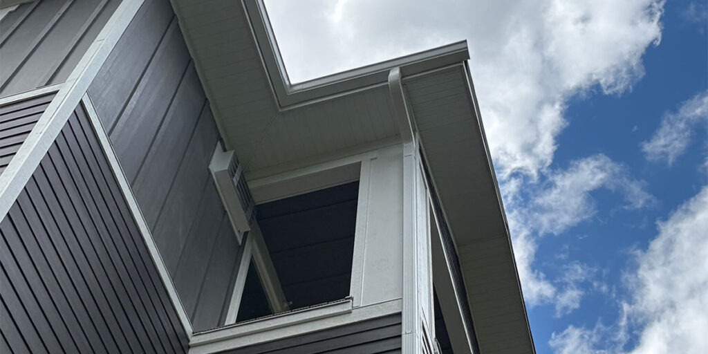 Modern home exterior with board and batten siding, soffit detail, and seamless gutter system