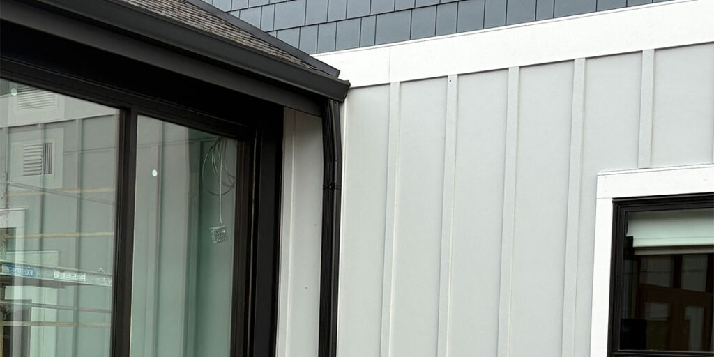 Modern board and batten siding with black-trimmed windows and exterior detail finish