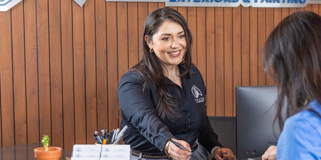 Prairie Exteriors team member assisting customer at front office reception desk